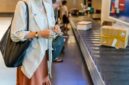 Seorang wisatawan menyiapkan paspor dan tiket penerbangan di bandara internasional sambil memegang dokumen asuransi perjalanan yang memberikan perlindungan selama berada di luar negeri.