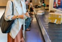Seorang wisatawan menyiapkan paspor dan tiket penerbangan di bandara internasional sambil memegang dokumen asuransi perjalanan yang memberikan perlindungan selama berada di luar negeri.
