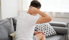 Neck pain, man suffering from ache at home, health problems concept