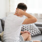 Neck pain, man suffering from ache at home, health problems concept